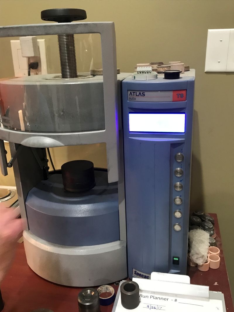 精製した炭素を高い圧力で円柱状に成形する自動油圧プレス機